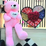 Luxury giant pink teddy bear with premium heart-shaped chocolate and flower gift box featuring KitKat, Ferrero Rocher, Dairy Milk chocolates, and fresh red roses for romantic surprises in Bangladesh.