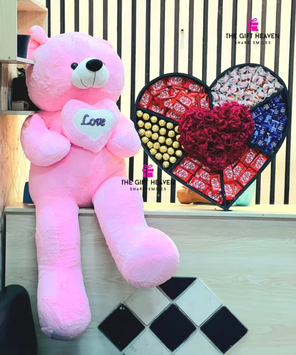 Luxury giant pink teddy bear with premium heart-shaped chocolate and flower gift box featuring KitKat, Ferrero Rocher, Dairy Milk chocolates, and fresh red roses for romantic surprises in Bangladesh.