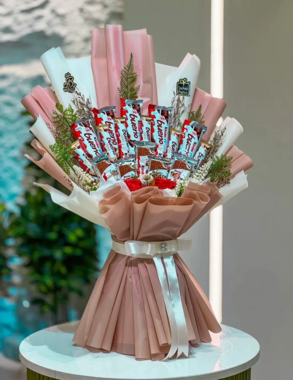 Luxury Kinder Bueno chocolate bouquet with premium wrapping, red roses, decorative greenery, and elegant white ribbon, handcrafted for birthdays, anniversaries, Valentine's Day, and special occasions in Bangladesh.